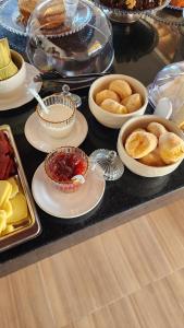 a table topped with bowls and plates of food at Pousada Recanto e Aconchego Capitolio in Capitólio