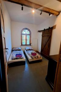 two beds in a room with a window and a door at Stara Szkoła S7 Noclegi Mazury, Zajezierze 8 14-330 Małdyty in Małdyty