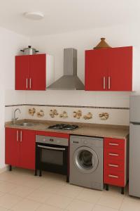 cocina con armarios rojos y lavadora en Panorama M'diq, en M'diq
