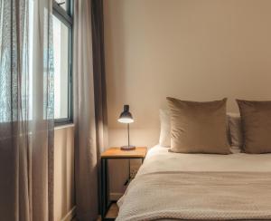 un lit avec une lampe sur une table à côté d'une fenêtre dans l'établissement Sunwave at Empire, au Cap 31 autres photos