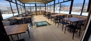 a restaurant with tables and chairs in a room with windows at 24seven Hotel Boutique in Duitama