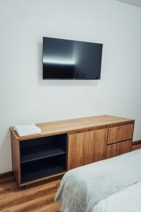 ドゥイタマにある24seven Hotel Boutiqueのベッドの上に壁掛け式の薄型テレビが備わります。