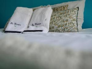 two towels on top of a white bed with pillows at La Galante, studio proche plage privée in Grand-Bourg