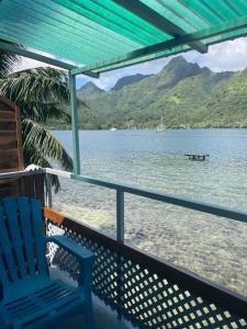 a blue chair sitting on a porch overlooking the water at Cottage Beach in Orufara