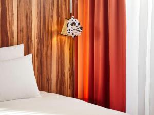 a bedroom with a bed and red curtains at Mama Shelter Rennes in Rennes +133 photos