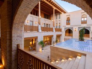 an indoor view of a hotel with a swimming pool at Mercure Bukhara Old Town in Bukhara