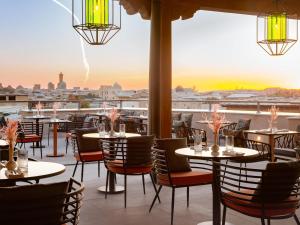 a restaurant with tables and chairs and a view of the city at Mercure Bukhara Old Town in Bukhara