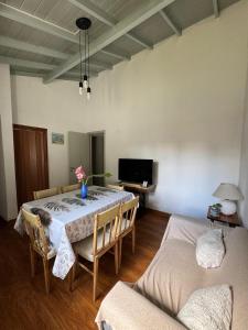 Un comedor con mesa y sillas y un televisor. en Casa DorisHouse, en Necochea