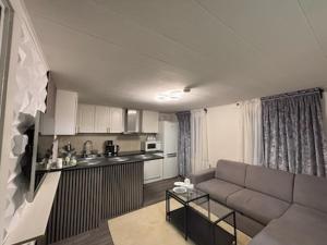 a living room with a couch and a kitchen at Stuga in Gothenburg