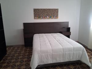 a bedroom with a large bed with a wooden headboard at la piazza in La Porteña