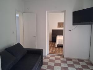 a living room with a couch and a bedroom at la piazza in La Porteña