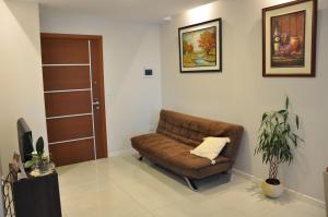 a brown leather couch in a room with a door at Condo en Cochabamba in Cochabamba