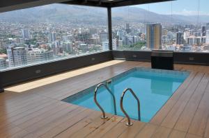a swimming pool in a room with a view of a city at Condo en Cochabamba in Cochabamba