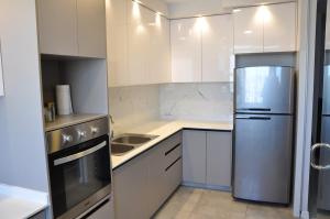 a kitchen with white cabinets and a stainless steel refrigerator at Condo en Cochabamba in Cochabamba