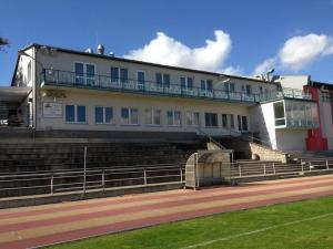 a large building with stairs in front of it at Hotel zum Sportforum in Blankenburg