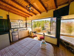 a bedroom with a bed and a large window at Cuesta de las Piedras in La Cumbrecita