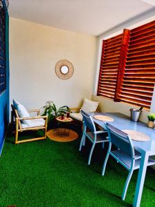 a room with a table and chairs and green grass at Evasion en plein cœur de la ville Studio Jacuzzis Sauna et piscine au centre de Port-Louis in Port-Louis +24 photos
