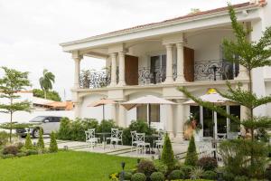 a building with tables and chairs in front of it at Hotel Boutique Las Mesetas in San Pedro Sula