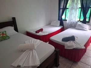 a room with three beds with red and white at Cabinas Tortuguero Natural in Tortuguero +34 photos