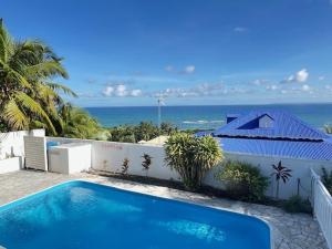 a swimming pool with a view of the ocean at Le 35 Anse des Rochers Saint-François in Saint-François