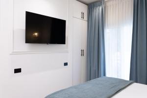 a bedroom with a bed with a television on the wall at Hotel Boutique Las Mesetas in San Pedro Sula