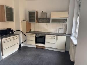a small kitchen with white cabinets and a sink at Wohnquartier GbR in Worms
