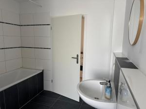 a white bathroom with a sink and a tub and a sink at Wohnquartier GbR in Worms +16 photos