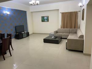 a living room with a couch and a tv at AL Sahab Tower in Manama