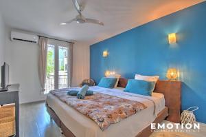a bedroom with a large bed with blue walls at Appartement 2 chambres sur la plage de grand case in Grand Case
