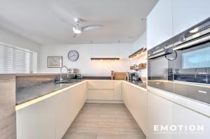 a kitchen with white cabinets and a counter top at Appartement 2 chambres sur la plage de grand case in Grand Case +16 photos