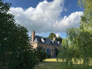 une grande maison en briques avec un toit bleu dans l'établissement La maison des apprentis sorciers Séjour enchanteur, 