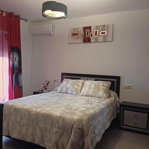 a bedroom with a bed with a white comforter at Cazorlasalud in Santo Tomé