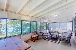 Una sala de estar con mesa y sillas y ventanas. en Garden Island's Birch, en Charlotte