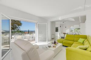 ein Wohnzimmer mit einem gelben Sofa und einem Tisch in der Unterkunft Amazing Villa Chimera White View Pool&Gym - Happy Rentals in Arezzo