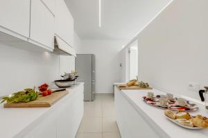 eine weiße Küche mit Tellern voller Essen auf einer Theke in der Unterkunft Amazing Villa Chimera White View Pool&Gym - Happy Rentals in Arezzo