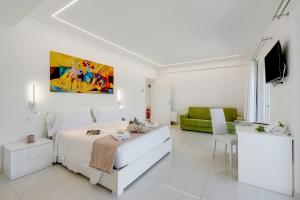 ein weißes Schlafzimmer mit einem Bett und einer Couch in der Unterkunft Amazing Villa Chimera White View Pool&Gym - Happy Rentals in Arezzo + 36 Fotos