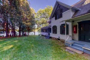 una casa blanca con un porche y un patio en Garden Island's Birch, en Charlotte