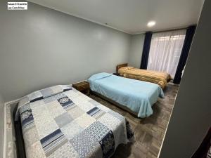 a bedroom with two beds and a window at Casas el Canelo in Isla Negra