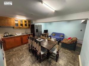 a kitchen and dining room with a table and a couch at Casas el Canelo in Isla Negra