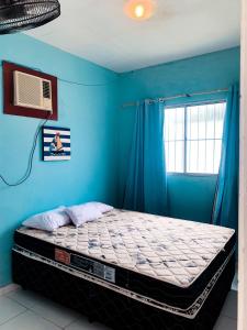 a bedroom with a bed with a blue wall at Refúgio Lumare in Maragogi