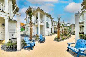 a row of houses with blue chairs and palm trees at Vida del Mar in Mustang Beach
