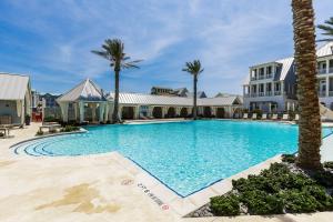 a large swimming pool with palm trees and buildings at Vida del Mar in Mustang Beach