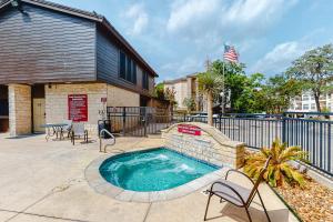 a swimming pool with chairs and a fence at Camp Warnecke Estates Unit B109 in New Braunfels