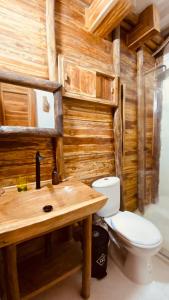 La salle de bains est pourvue de toilettes et d'un mur en bois. dans l'établissement Rocha Beach Club, à Playa Blanca