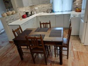 a kitchen with a wooden table with chairs and a white refrigerator at Et In Arkadia Ego in Leonidion +22 photos