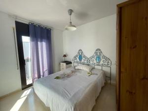 a bedroom with a large bed and a window at 1 La Cala Palamós in Palamós
