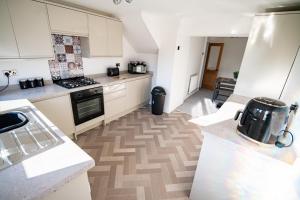 eine Küche mit weißen Schränken und einem Herd mit Backofen in der Unterkunft Cottage in Seaton in Siddick + 3 Fotos