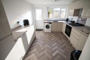 eine Küche mit Waschmaschine und Trockner in der Unterkunft Cottage in Seaton in Siddick