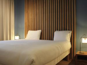 a bedroom with a large bed with two pillows at Aparthotel Adagio Montpellier Centre Comedie in Montpellier +32 photos