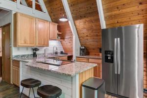 a kitchen with a stainless steel refrigerator and wooden cabinets at Cozy A-frame Cabin At Schuss Mt 5 Mins To Ski in Bellaire